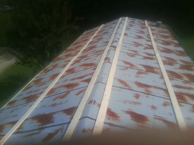 Rusted metal roof panels with new wood purlins before replacement — Storm Damage Roof Repair in Steamboat Springs by Roofing Brothers