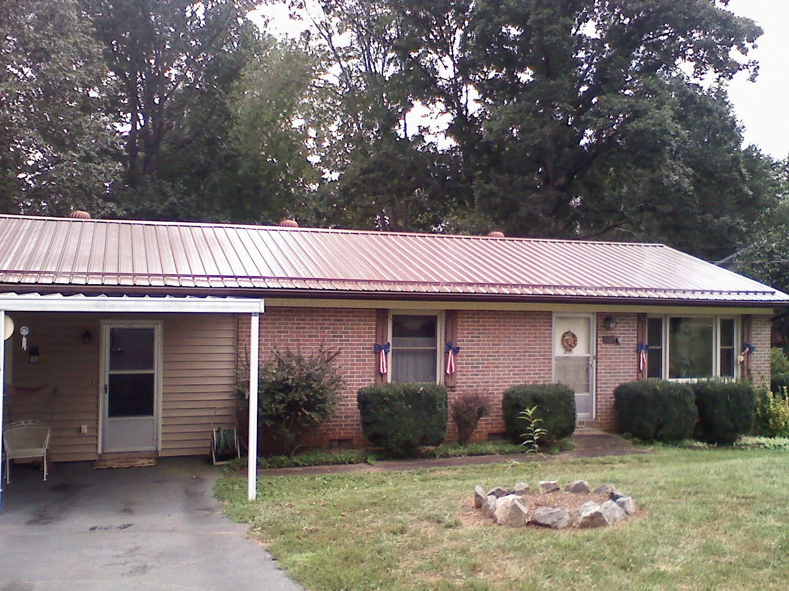 Bronze metal roof and carport on a brick ranch home — Roof Repair work by our crew in Steamboat Springs
